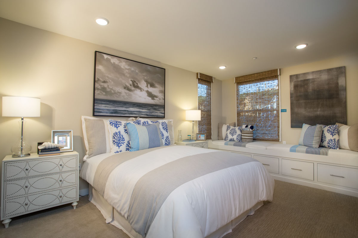 Bedroom with white decor and blue accents at The Strand