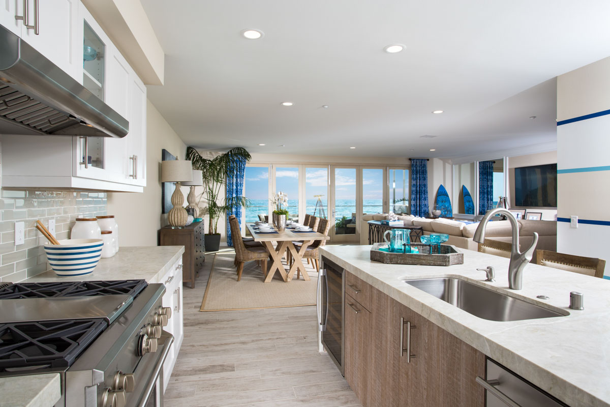 Bright and airy coastal kitchen over looking modern living room at The Strand