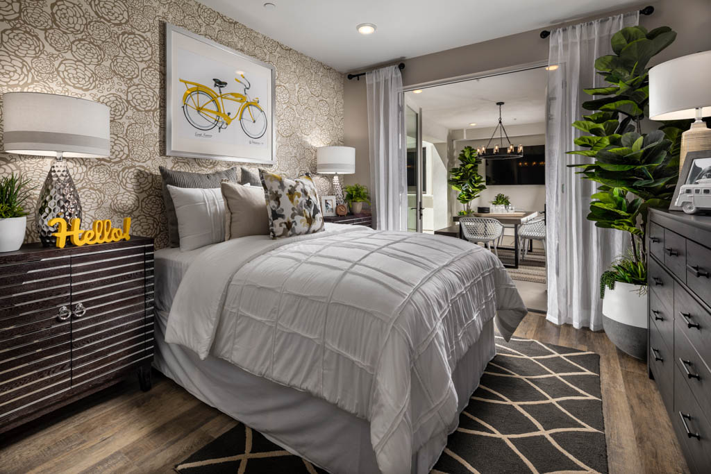 Second bedroom with flower pattern accent wall and hints of yellow decor at Carlyle