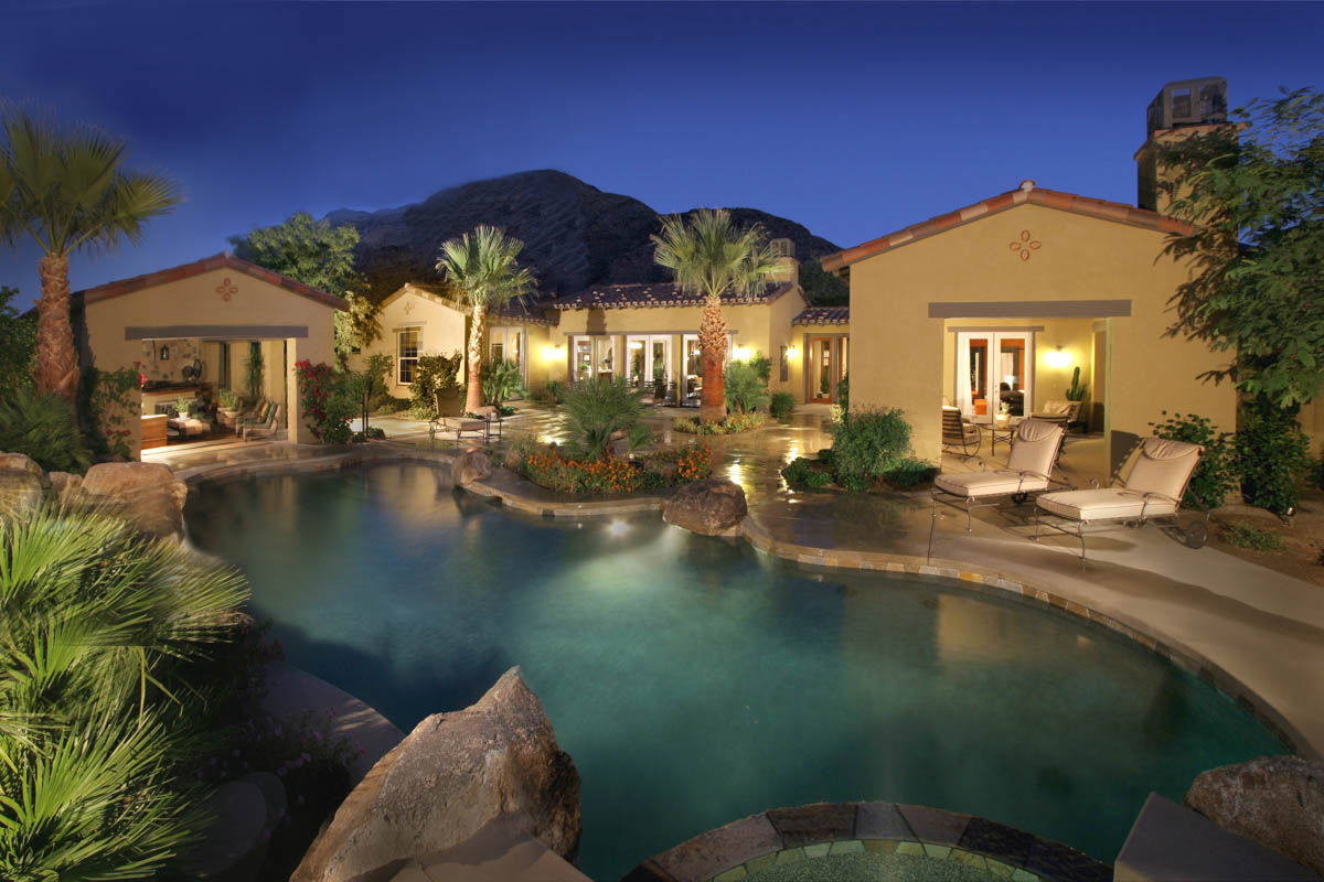 Pool area of the Monte Sereno home illuminated and encompassed with palm trees