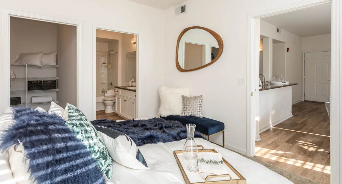 Master bedroom with a view to the bathroom, closet and kitchen area at the Terraces at Highland development