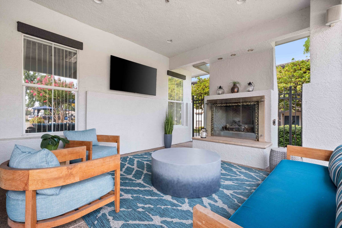 Resting area with outdoor fireplace and blue chairs at the Terraces at Highland development
