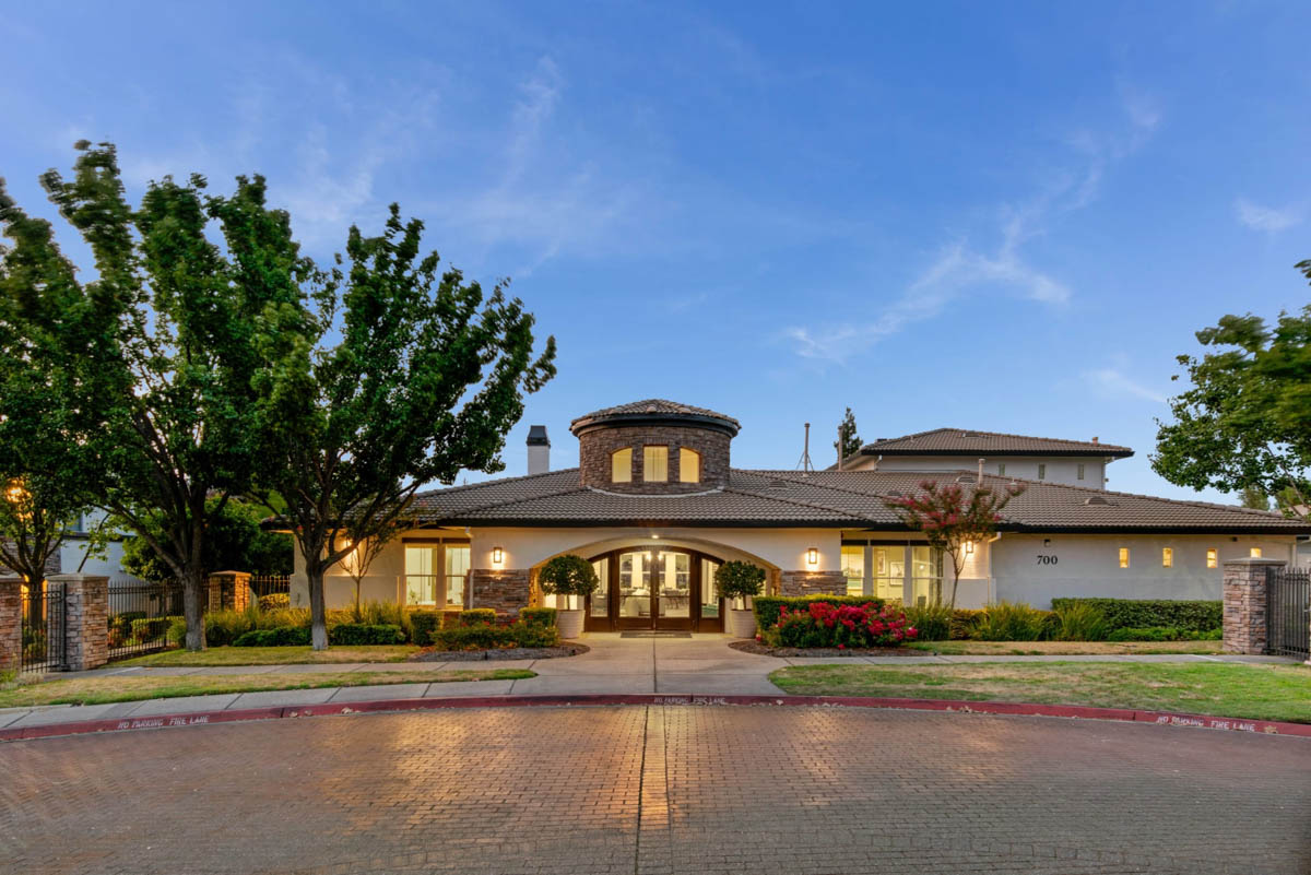 Front exterior view of the clubhouse at night at the Terraces at Highland development