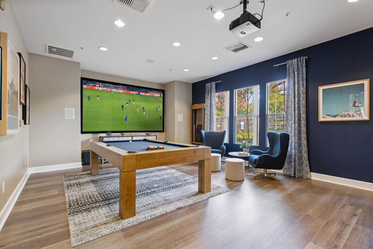 Pool table with large screen tv playing soccer at the Terraces at Highland development